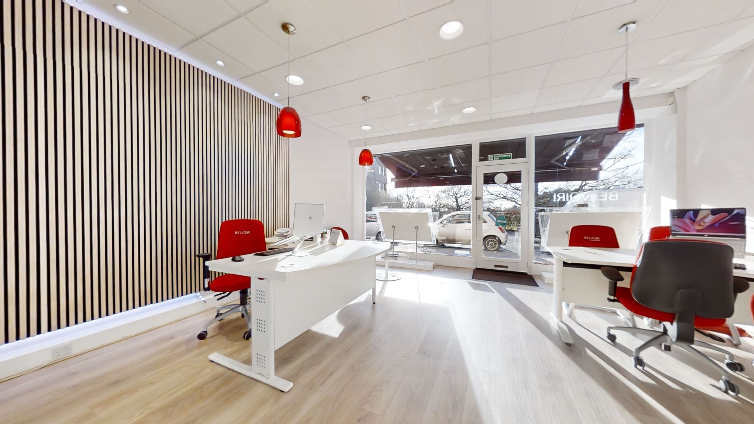 Open-plan lettings office fit-out with oak-slatted acoustic wall, warm vinyl flooring and recessed lighting, Belvoir Haywards Heath