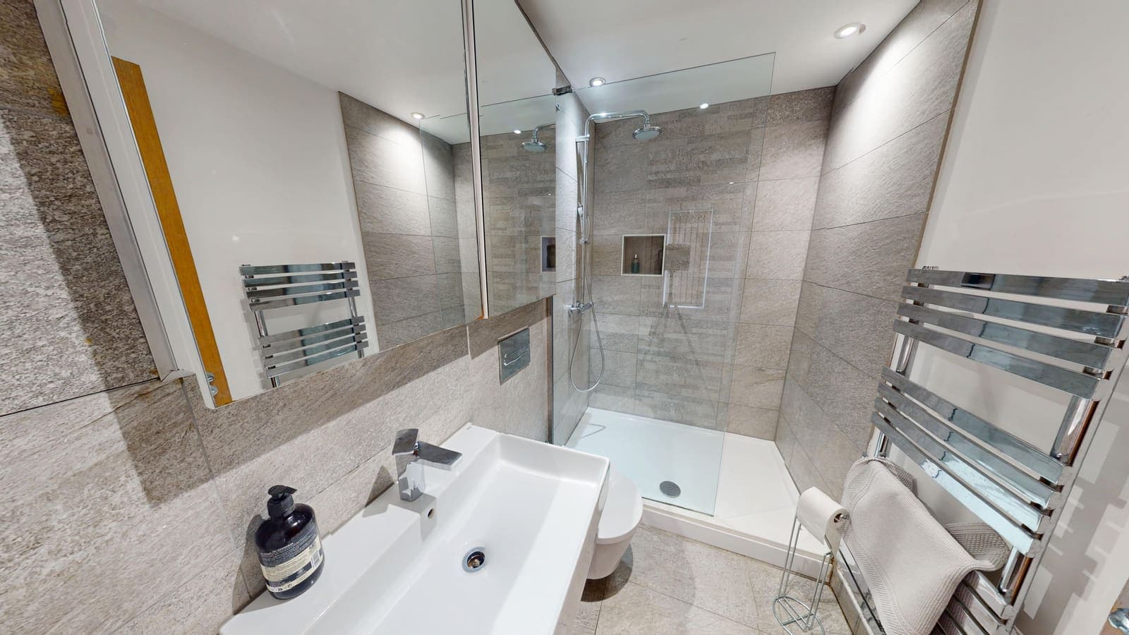 Contemporary bathroom with grey porcelain tiles, fitted bath and overhead shower, Brighton