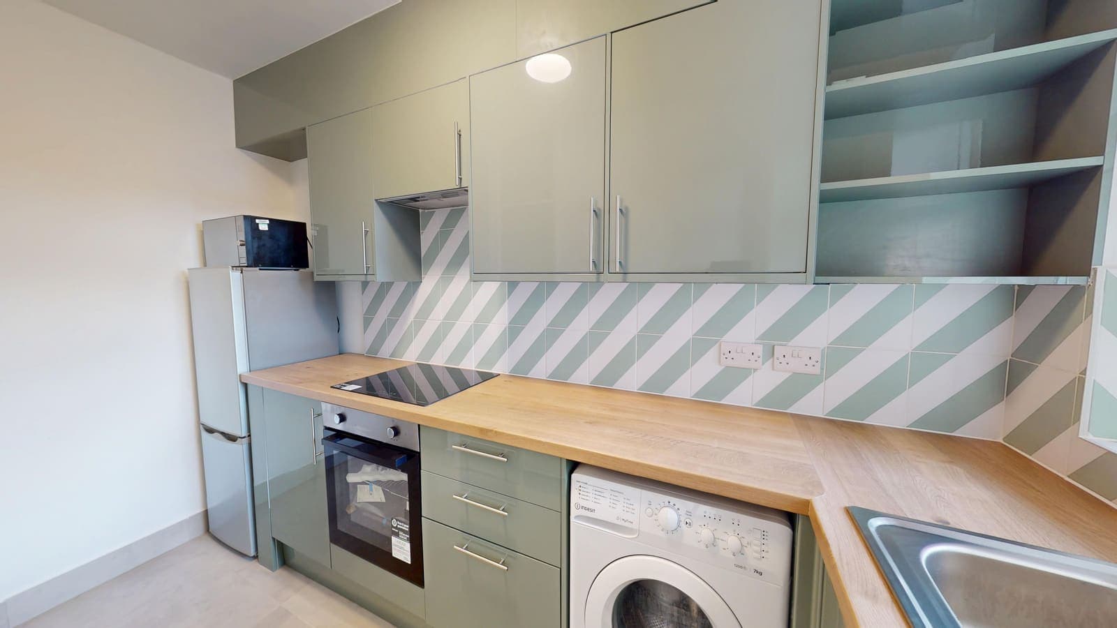 Sage green kitchen renovation with chevron tile splashback and integrated appliances, Coniston Court