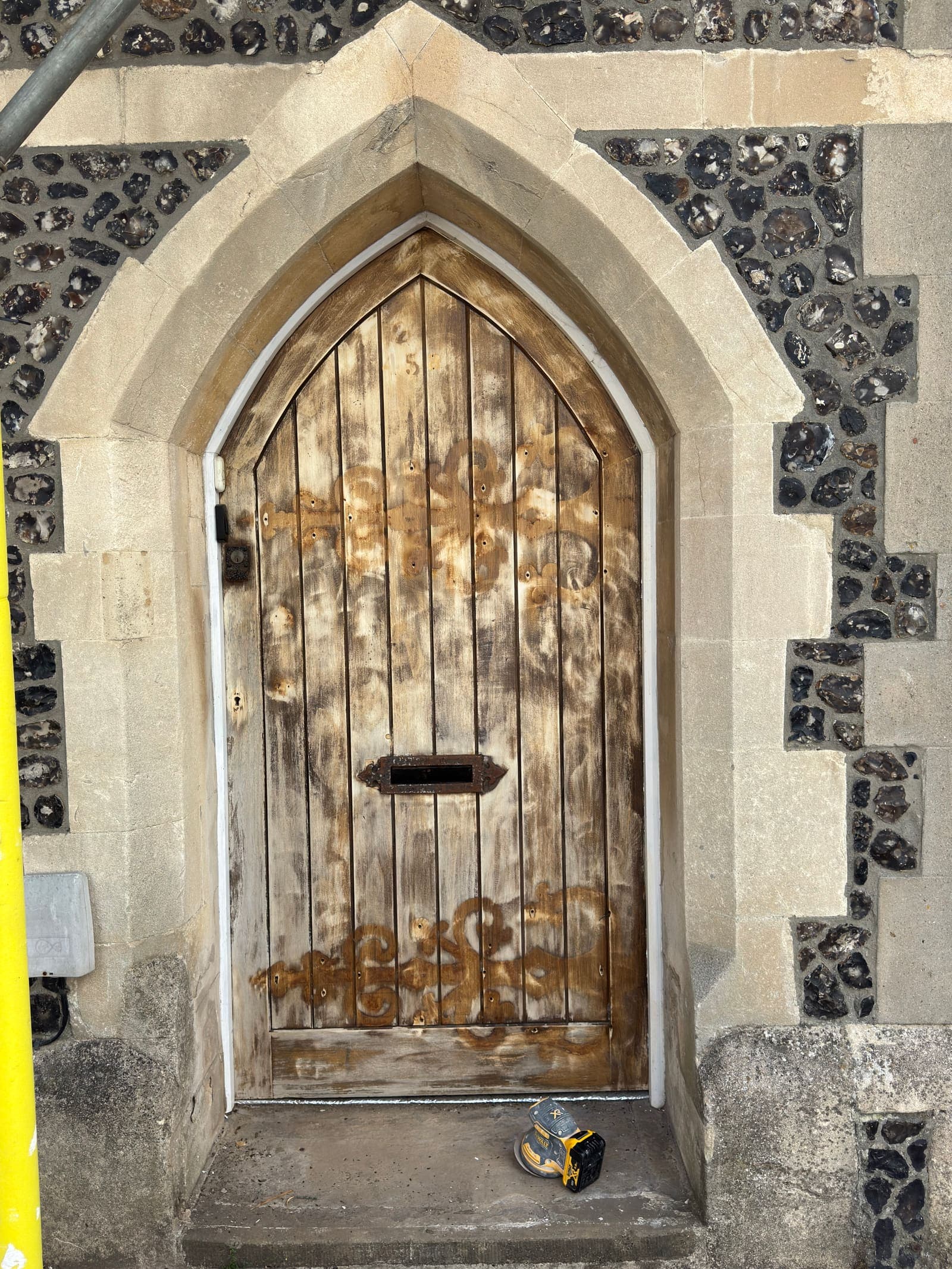 Weathered arched timber front door before restoration, Brighton
