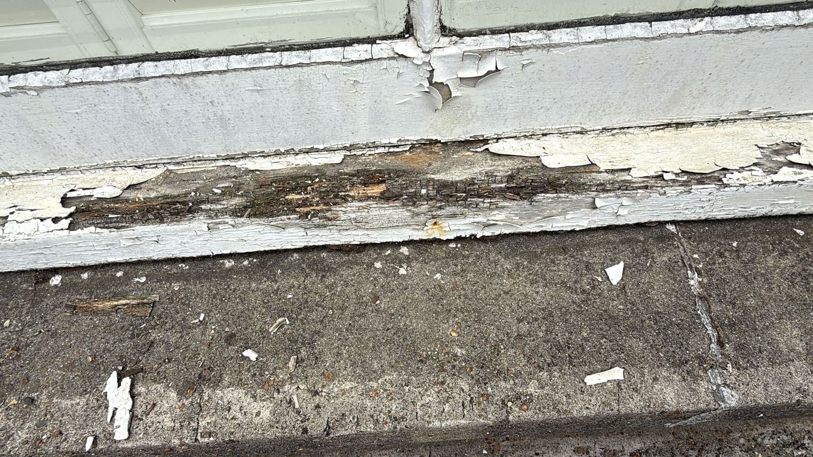 Rotten painted window sill and decayed render before repair, Brighton