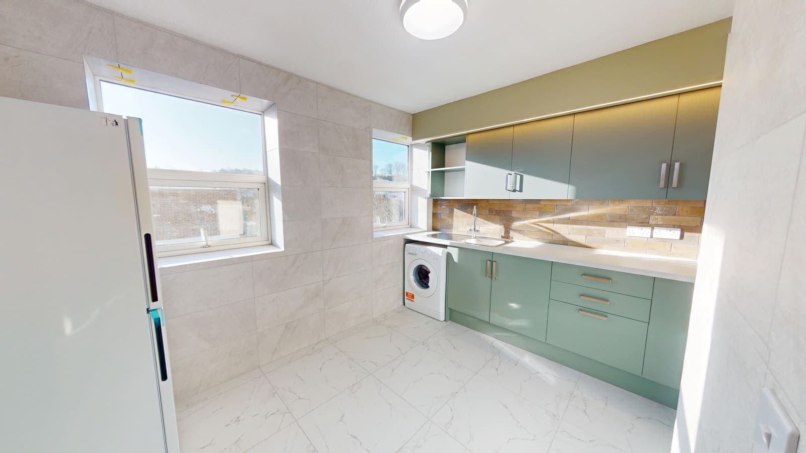 Sage green shaker kitchen with timber worktops fitted in Brighton by Essence Construction