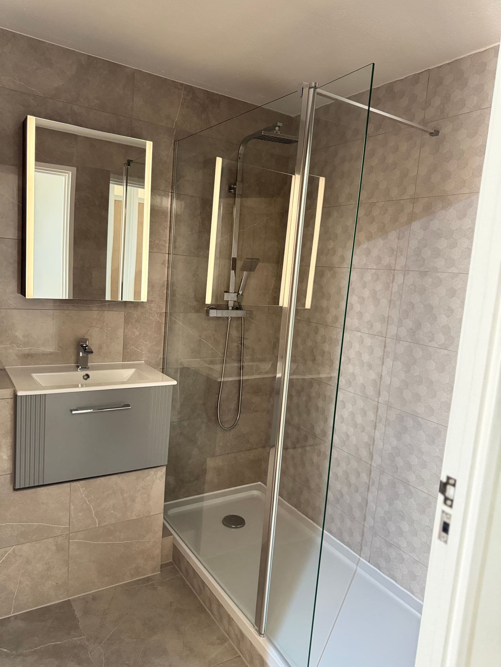 Renovated grey shower room with wall-hung vanity and walk-in shower, Osprey House Hove