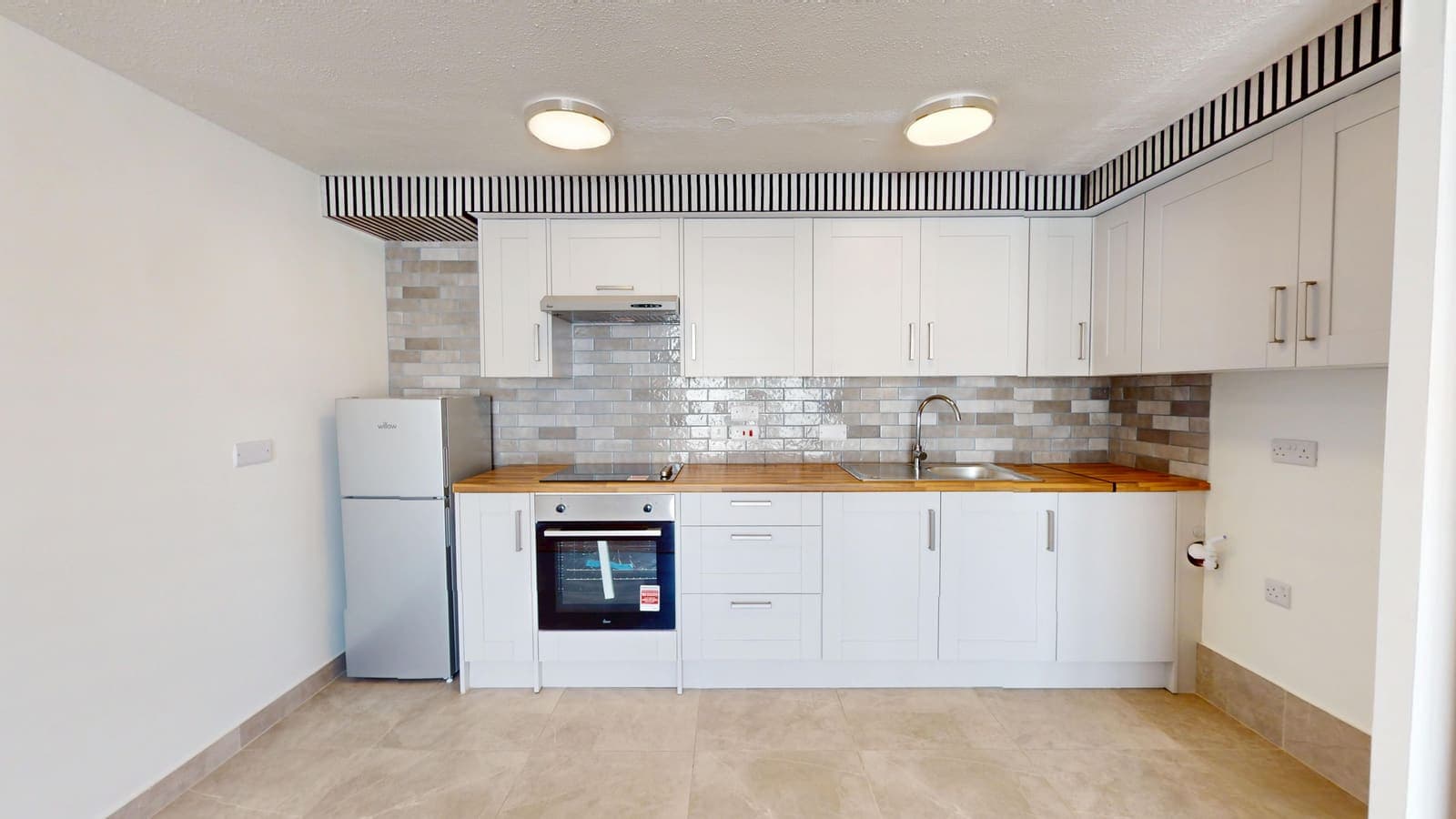White kitchen refit with marble-effect splashback and integrated fridge, Osprey House