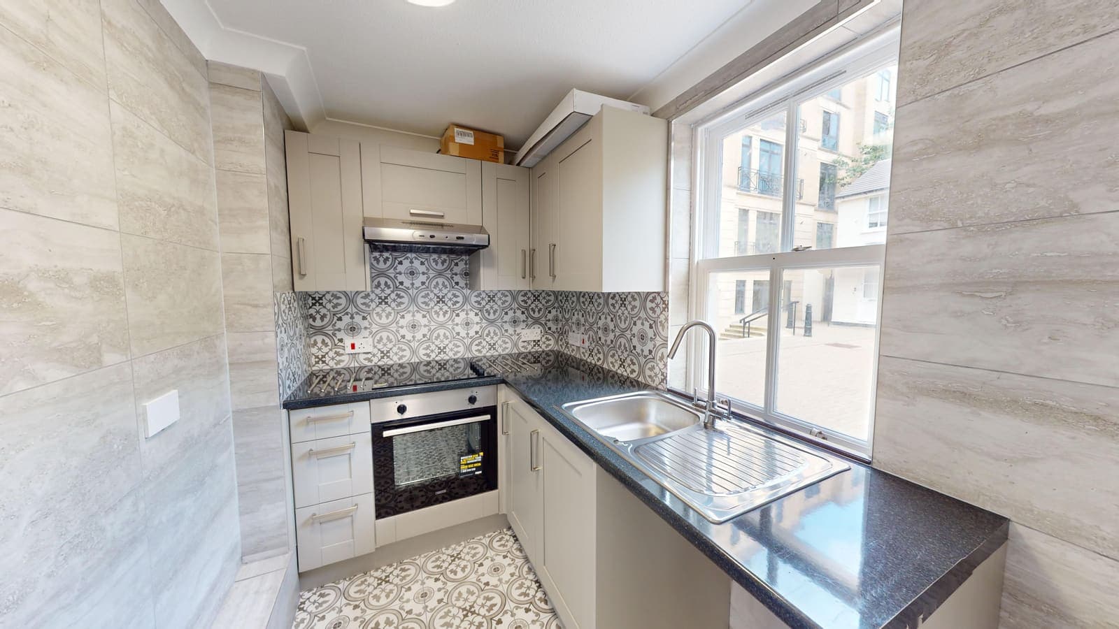 Kitchen renovation with dark stone-effect worktop and patterned splashback, Russell Mews Brighton