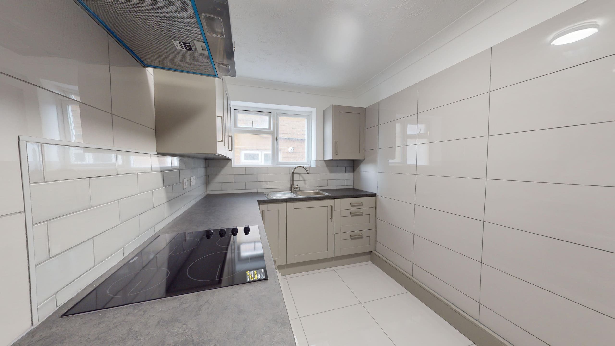 White fitted kitchen with grey worktops, metro tiles and black induction hob, Warwick Court