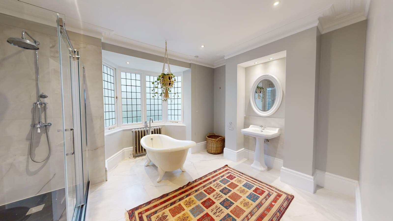 Luxury renovated bathroom with marble-effect tiling, walk-in shower and freestanding bath at Western Road, Brighton